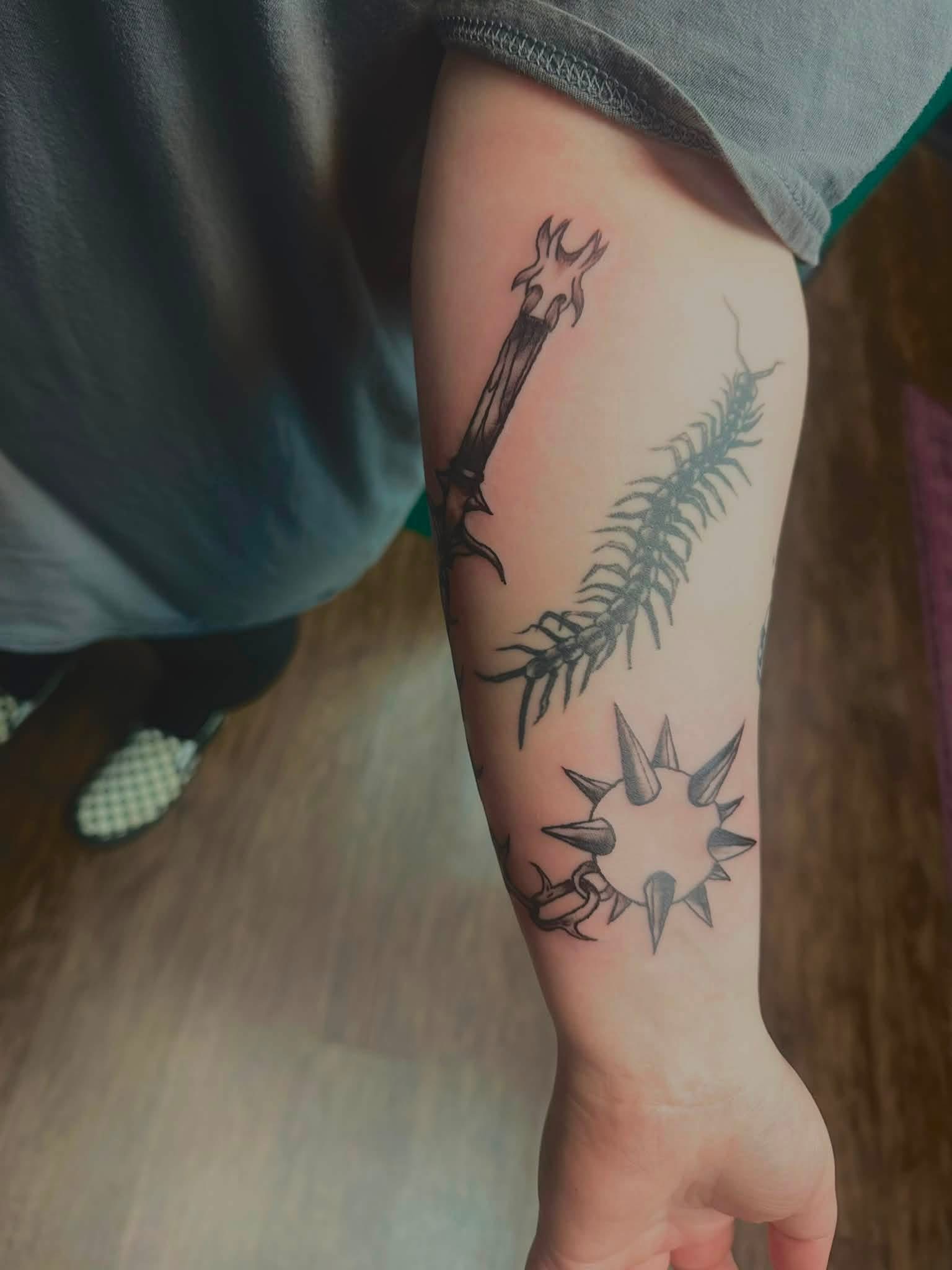 Spiked ball, centipede, and staff tattoo